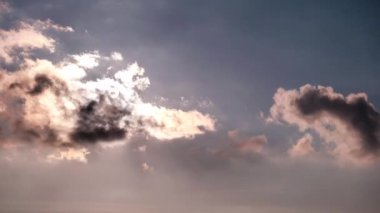 Turuncu bulutların arasından gökyüzünde güneş ışınlarıyla dramatik günbatımının zamanı. Büyük parlak turuncu güneş ufukta aşağı doğru hareket ediyor. Müthiş destansı bulut uzayı, canlı bir renk. Zaman aşımı. Gün batımı. 4K