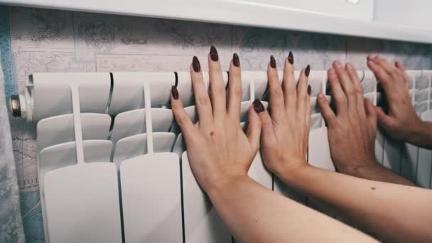 Några Värmer Händerna Värmeelementet Vid Väggen Frysta Manliga Och Kvinnliga — Stockvideo