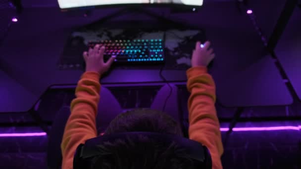 게이머는 게임기 의자에 스포츠 클럽에서 비디오 게임을 네온등 컴퓨터 클럽의 — 비디오