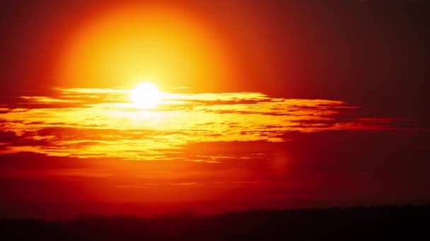 地平線上のオレンジ色の空の柔らかい雲を通して劇的な日没をタイムラプスします 太陽の光が降り注ぐ大きな赤い太陽 素晴らしい壮大な雲の空間 鮮やかな色 タイムラプス 黄色の空の日没 — ストック動画