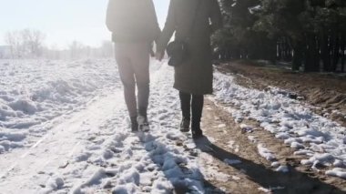 İki kız kış ormanında el ele yürüyorlar. Yavaş çekimde, dikiz aynasıyla. Parlak güneşe karşı kar yolunda yürüyen kadın kız arkadaşlar. Sevgi dolu bir çift adımın arka görüntüsü. LGBT, lezbiyen