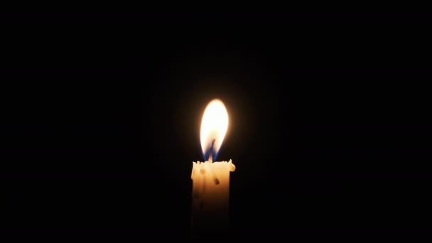 蜡烛在黑色的背景上燃烧 黄色的单闪烁的蜡烛照亮了黑暗 孤立无援 科皮斯概念记忆 宗教或庆祝活动 炽热的火光飘扬 — 图库视频影像