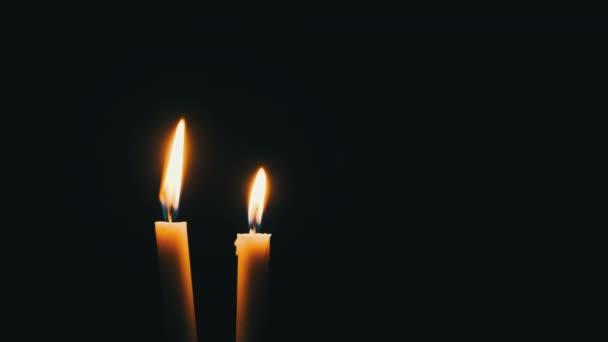 Two Candles Lit Black Background Close Yellow Flickering Flame Illuminates — Vídeo de stock