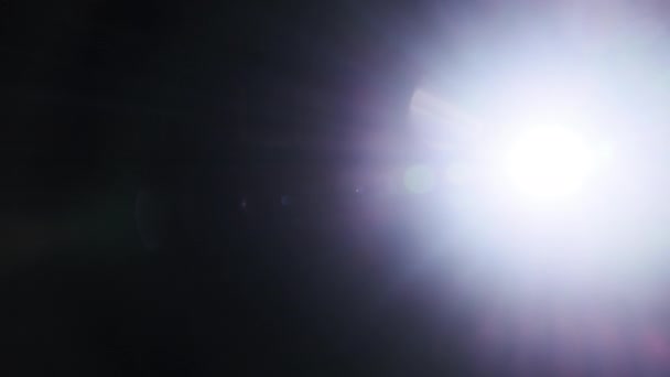 在黑色背景上的手电筒射进相机的光线 强光照射在相机镜头上的光效果 蓝色数码相机闪光灯 抽象覆盖背景 — 图库视频影像