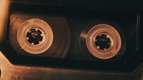 老式录音机中的盒式磁带回放 唱机在摇曳的灯光下播放着老式的透明盒式磁带 复古磁带卷轴在甲板上旋转 记录电话 80年代 — 图库视频影像