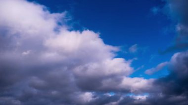 Kümülüs bulutlarının mavi gökyüzünde hareket etme zamanı. Karanlık ve aydınlık bulutların şekil değiştirdiği yaz bulutlu bir yer. Atmosfer arkaplanı, zaman atlaması. Hava değişikliği. Doğa, Gökyüzü bulutları, boşluğu kopyalayın