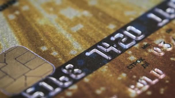 信用卡旋转得很近 塑料银行卡在宏观上旋转 网上购物和零售购物的支付方法 黄金借记卡上的芯片和数字塑料 概念货币 — 图库视频影像