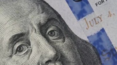 100 $'lık banknot yakın çekim yap. Benjamin Franklin portresiyle yüz dolarlık banknotu döndürmenin uç noktası. Nakit para geçmişi. Amerikan doları nakitinin detaylı görüntüsü. İş, yatırım