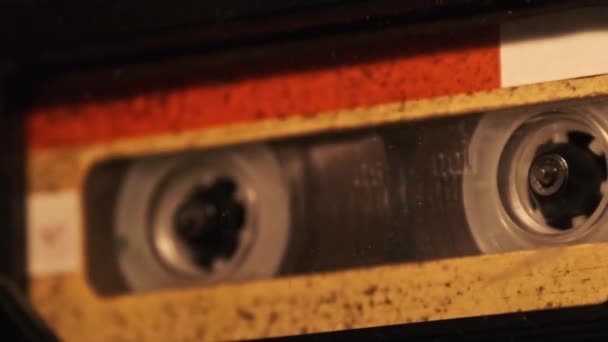 ヴィンテージテープレコーダーでのオーディオカセット再生 古い黄色のオーディオカセットをちらつきキャンドルライト クローズアップで再生しているレコードプレーヤー レトロテープリールはデッキで回転します 通話記録 アーカイブ 80年代 — ストック動画