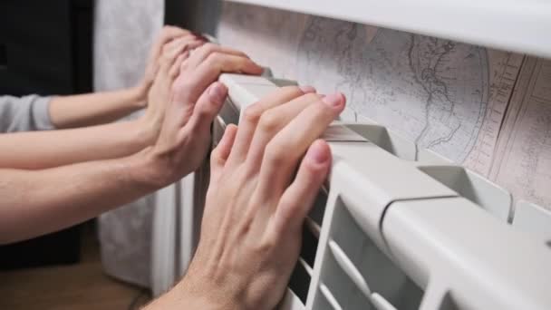 手は放熱器によって暖められます 冷凍男性と女性の手は 家庭用バッテリーに触れ 暖かくしようとします 寒い季節の概念の間の家の温度および暖房家 アパートの寒さ — ストック動画