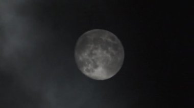 Gece gökyüzündeki dolunay kara bulutların arasında parlıyor. Mistik ay ışığı. Ayın önünden geçen gerçek karanlık ve gizemli bulutlar. Kara fırtınalı bulutlar ve ay.