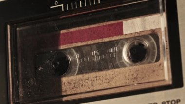 Retro teypte ses kaseti oynatıcısı. Eski sarı ses kasetini çalan bir pikap, yakın plan. Antika kasetler güvertede dönüyor. Konuşmalar kaydediliyor, 80 'ler, arama kaydı, retro çalma