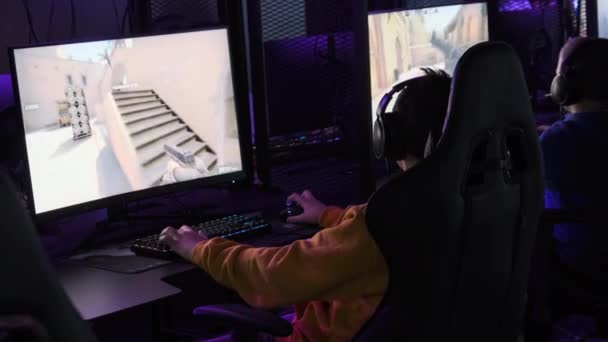 게이머는 게임기 의자에 스포츠 클럽에서 비디오 게임을 네온등 컴퓨터 클럽의 — 비디오
