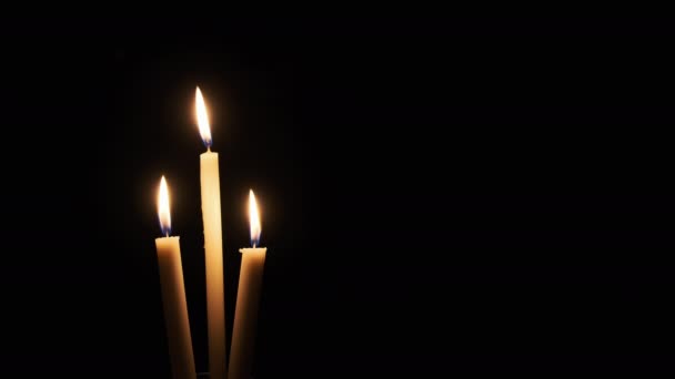 三支蜡烛在黑色背景上点燃 黄色闪烁的火焰照亮了黑暗 夜间燃烧着的温暖的火光 随风飘荡 孤立无援 科皮斯4K — 图库视频影像