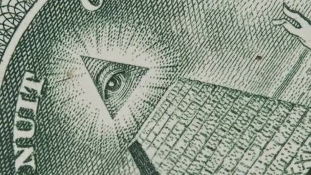 すべての目のサインは 1ドル札のクローズアップで回転します メイソンの記号だ 概念インフレ経済陰謀 ピラミッドとメイスンの目を持つマクロの米国銀行券 新しい世界秩序エリート — ストック動画