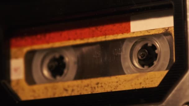 カセットは 柔らかいちらつきのキャンドルライト クローズアップでテープレコーダーで再生されます デッキの黄色いオーディオカセットが回転します 古いレトロなレコーダーでヴィンテージサウンドレコーディング オーディオカセット再生 — ストック動画
