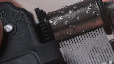 Retro music box mechanism with spinning cylinder and cogs in macro. Old music box clockwork device with rotating drum with projections touching the records creates music. Toy barrel organ rotates. 4K