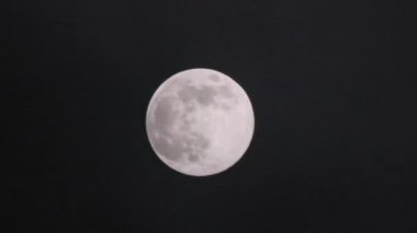 Gece gökyüzündeki dolunay kara bulutların arasında parlıyor. Mistik ay ışığı. Ayın önünden geçen gerçek karanlık ve gizemli bulutlar. Kara fırtınalı bulutlar ve ay.