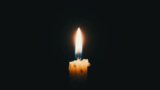 One Candle Lit Black Background Close Yellow Flickering Flame Illuminates — Vídeo de Stock