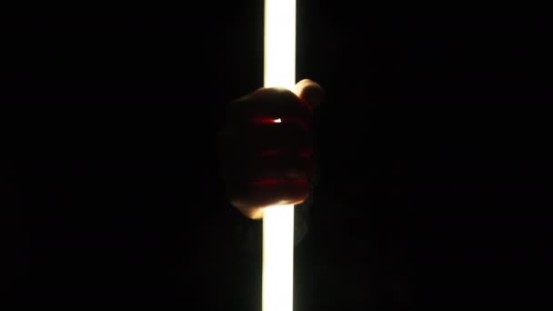 Αρσενικά Χέρια Κρατούν Ένα Φωτόσπαθο Νέον Μαύρο Φόντο Αντρικά Δάχτυλα — Αρχείο Βίντεο