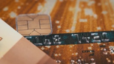 Kredi kartı sırayla kapanır. Plastik banka kartı makroda dönüyor. Çevrimiçi ve perakende alışveriş için ödeme yöntemleri. Plastik üzerinde çip ve numaralar olan altın banka kartı. Para, tasarruf, kredi kavramı