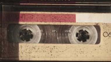 Klasik kayıt cihazında ses kasedi oynatıcısı. Eski sarı ses kasetini çalan bir pikap, yakın plan. Retro bantlar güvertede dönüyor. Konuşmalar kaydediliyor, 80 'ler, arşiv kaydı, çağrı