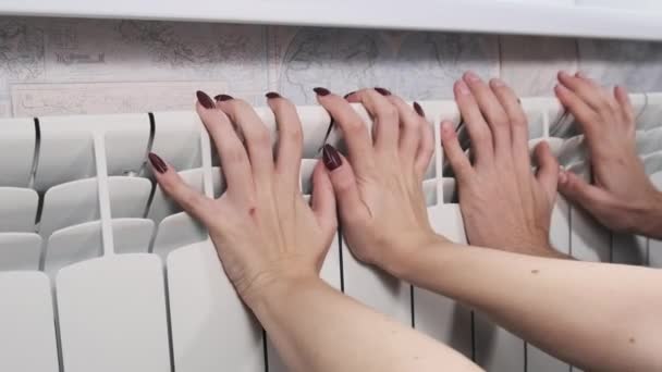 冰冷的男男女女的手触摸着家用散热器 试着热身 家庭取暖问题 寒冷季节的室内温度概念 手被加热电池加热了 公寓里很冷 — 图库视频影像