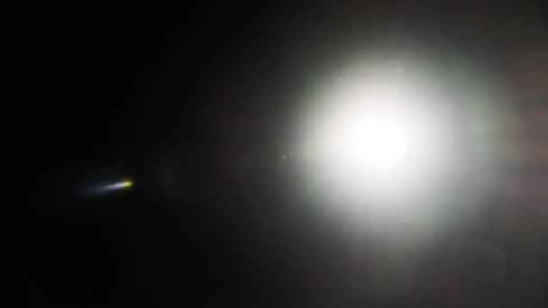 指向相机的明亮的手电筒的光从侧面移动到侧面 镜片反射的光效应 蓝光的闪光 镜头耀斑 光线泄漏 — 图库视频影像
