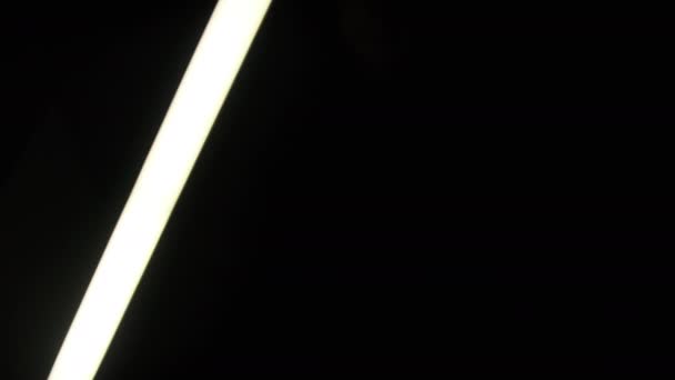 白色荧光棒在黑色背景上左右移动 明亮的白色霓虹灯Led剑用于视频转换效果 发光的管状手电筒 摘要背景 — 图库视频影像