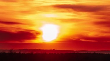 Timelapse of sunset in the orange sky moving down over the horizon. Awesome big bright red sun with sunrays moves through clouds. Epic cloud space, vibrant color. Time Lapse. Big sundown, closeup
