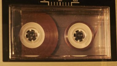 Retro teypte ses kaseti oynatıcısı. Eski şeffaf ses kasedini çalan bir pikap, yakın plan. Antika kasetler güvertede dönüyor. Konuşmalar kaydediliyor, 80 'ler, çağrı, retro çalma