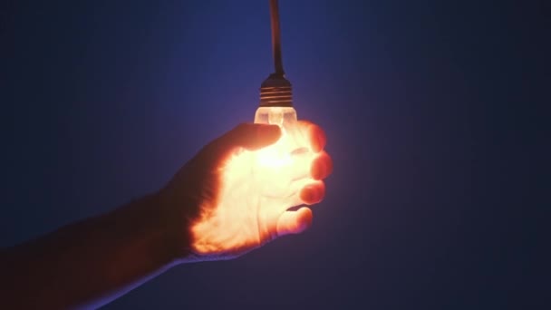 Žárovka Rozsvítí Zabliká Mužské Ruce Tmavomodrém Pozadí Žárovka Drátě Svítí — Stock video