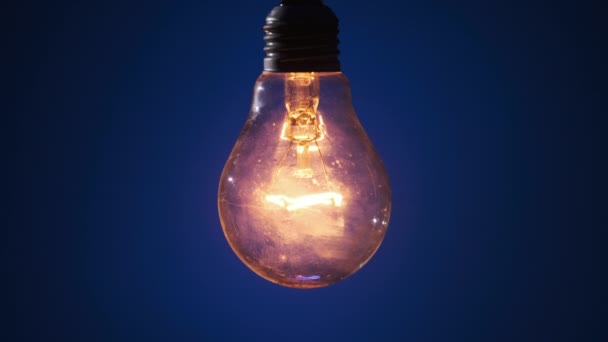 Lámpara Incandescente Ilumina Parpadea Sobre Fondo Azul Oscuro Bombilla Clásica — Vídeos de Stock