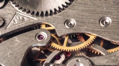 Timelapse of mechanism of vintage stopwatch with rotation close-up. Round clock watch mechanism working, macro. Old retro clockwork gears, cogwheels, and pendulum movement inside the ancient clock. 4K