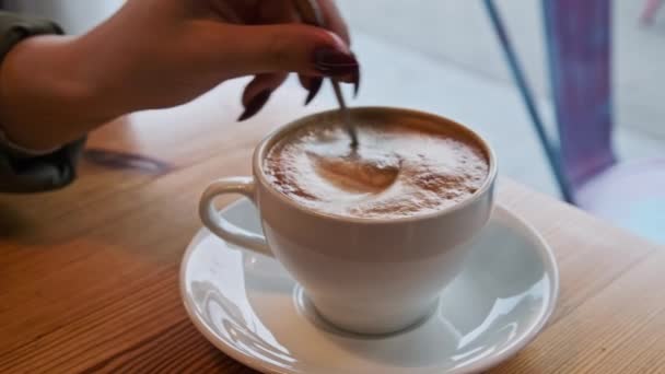 Tangan Gadis Mengaduk Busa Dengan Sendok Cangkir Cappuccino Menghadap Jalan — Stok Video