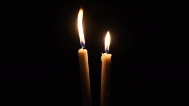 Siyah arka planda iki mum yanar. Sarı yanıp sönen mumlar karanlığı aydınlatıyor, yakından. Anma, din ya da kutlama kavramını unutmayın. Ateşin sıcacık parıltısı sallanıyor. İzole edilmiş, Kopyalama