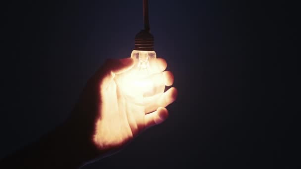 Retro Bulb Glows Flickers Male Hand Dark Blue Background Incandescent — Stockvideo