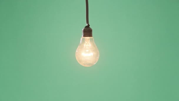 Incandescent Lamp Glows Flickers Green Background Edison Light Bulb Slowly — Video Stock