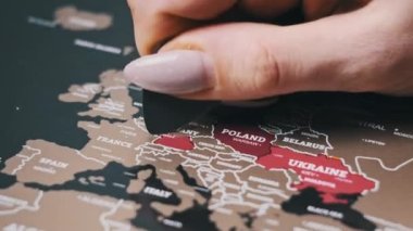 Female Hand Scratching Germany Country on the Surface of Scratch World Map. Scratch world map with Europe countries, close-up. Scratching visited countries on travel map. Erase country on scratch map
