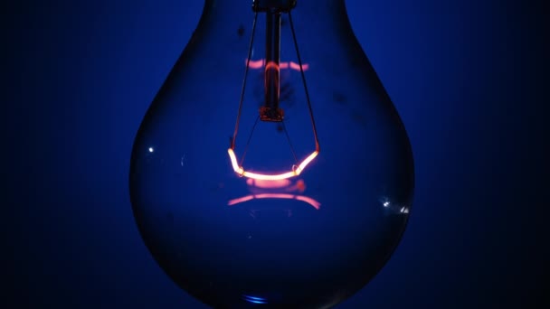 Incandescent Bulb Glows Flickers Dark Blue Background Edison Bulb Slowly — Stock Video