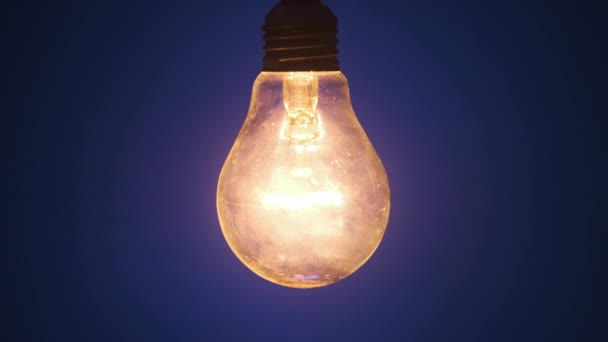 Incandescent Lamp Lights Flickers Dark Blue Background Classic Bulb Slowly — Stock Video