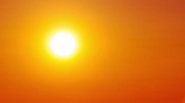 Ufuktaki turuncu gökyüzünde gün batımının zamanı. Güneş ışığıyla birlikte büyük, parlak kırmızı güneş akşam sisi içinde aşağıya doğru hareket ediyor. Müthiş destansı bulut uzayı, canlı bir renk. Zaman aşımı. Gün batımı