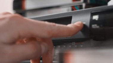 Video oynatıcıdan VHS kaseti çıkar. Erkek el, birçok arşivlenmiş video kaset içeren eski bir video kayıt cihazından VHS çekiyor. VHS retro oynatıcı. Ev videosu kavramı, eski teknoloji