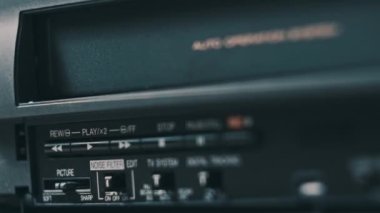 Video oynatıcıya VHS kaset ekle. Masada bir sürü arşivlenmiş video kaset kaydedici var. Erkek el, eski VHS kaseti retro oynatıcıya sokuyor. Ev videosu, nostalji.