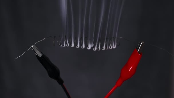 尼可洛梅金属丝在高电流下被烟加热成红色 尼可洛梅长丝呈螺旋状连接到实验室电线上 金属电阻高 电流强度 — 图库视频影像
