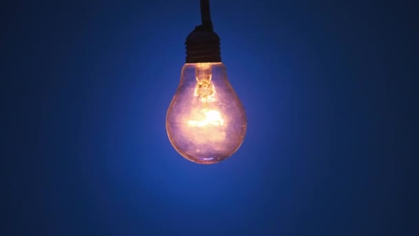 Lâmpada Incandescente Brilha Pisca Fundo Azul Escuro Lâmpada Edison Lentamente — Vídeo de Stock