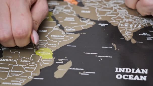 Žena Vymazává Navštívenou Zemi Tanzanie Cestovní Mapě Škrábání Země Povrchu — Stock video