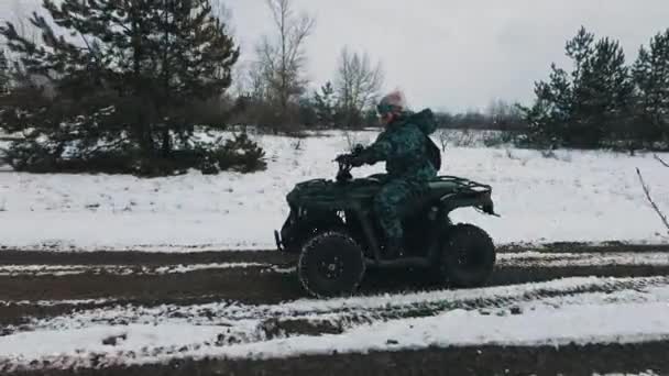 女人骑着一辆越野车穿过雪地 四轮驱动的自行车在雪地覆盖的小径上行驶 在雪地里骑四轮四轮驱动的四轮驱动车 寒假越野赛 生活方式 — 图库视频影像
