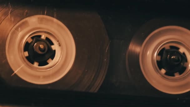 盒式磁带在软软摇曳的灯光下 在录音机里播放 甲板上透明的盒式磁带旋转 老式留声机中的老式录音 盒式磁带播放 — 图库视频影像