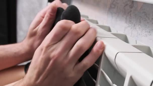 Männliche Hände Und Weibliche Füße Socken Die Auf Einem Heizkörper — Stockvideo